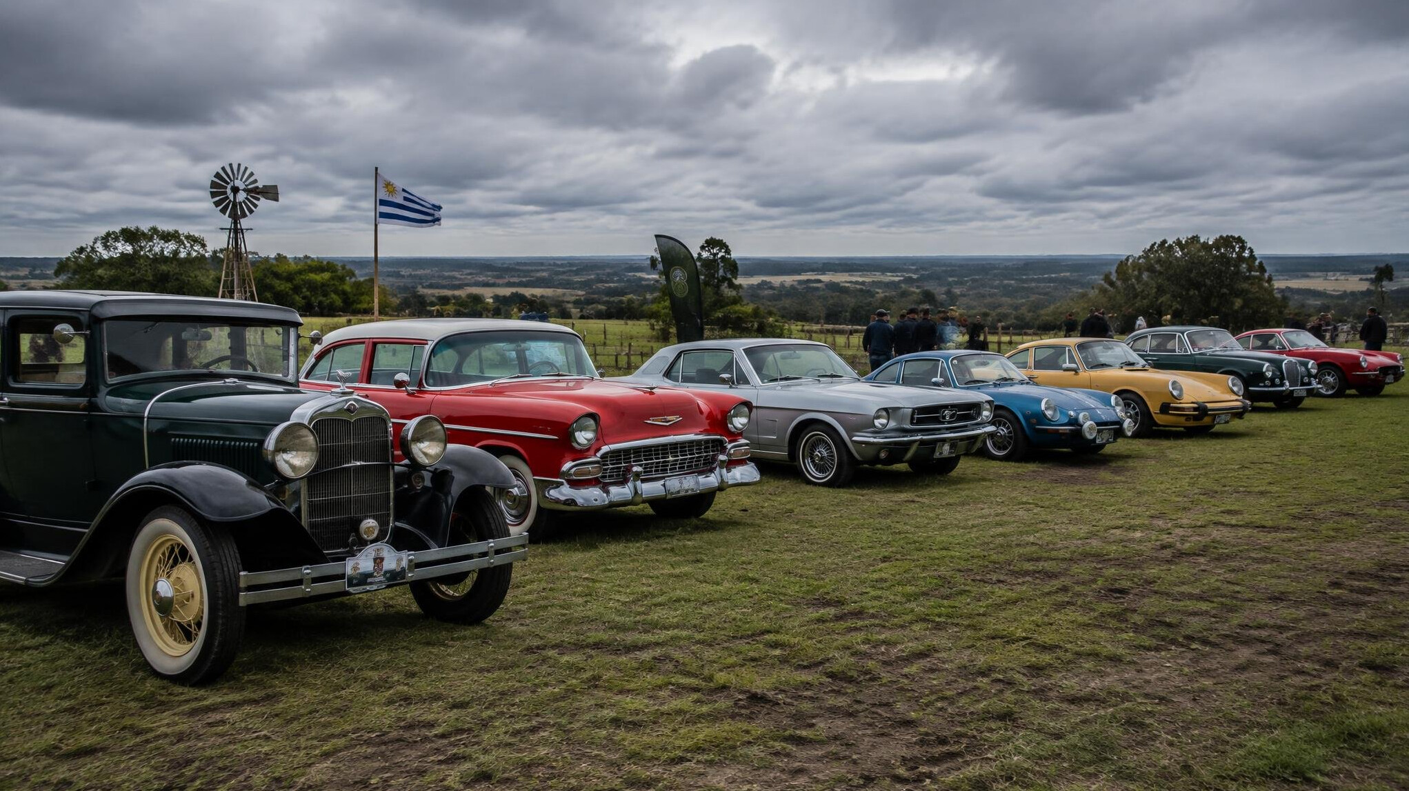 Row of classic automobiles lined up at a countryside rally in Canelones